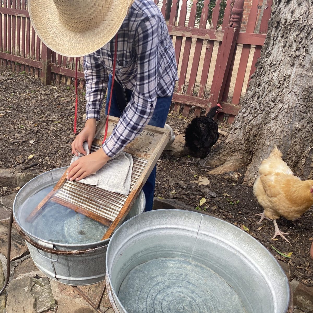 Man washing clothes with a washboard in a tub