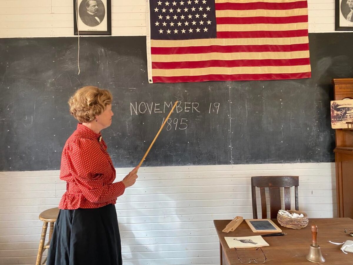 Woman teaching inside old schoolhouse
