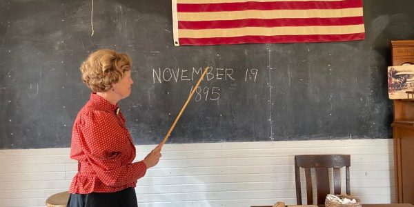 Woman teaching inside old schoolhouse
